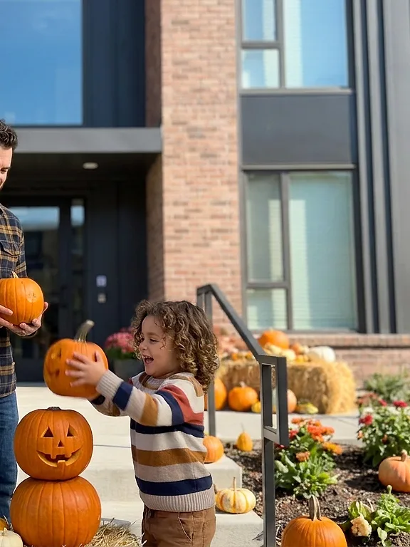 A family with pumpkins at a building entrance, Halloween